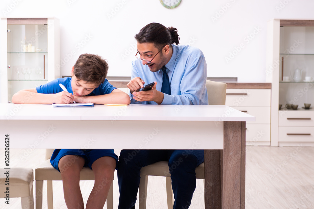 Busy father helping his son to prepare for exam