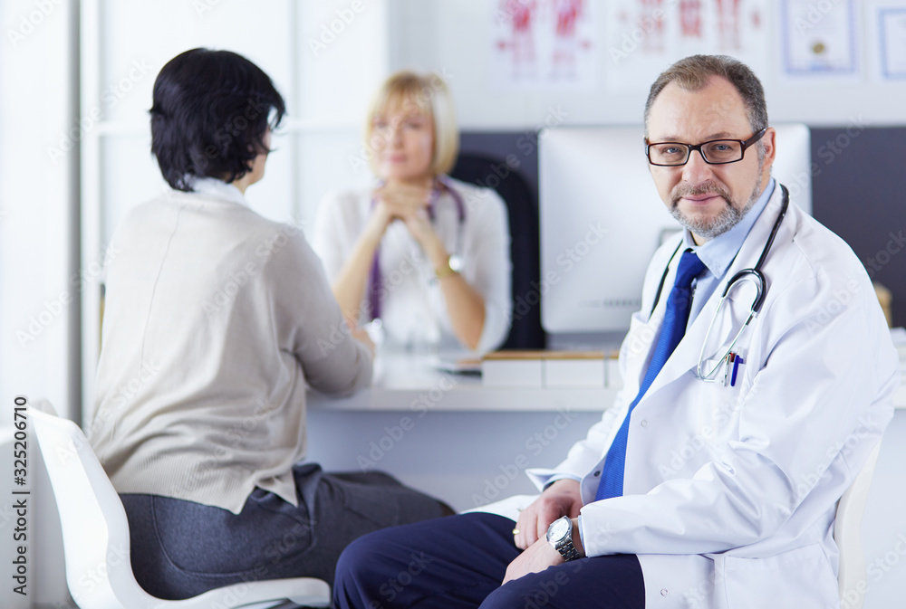 Portrait of senior doctor in office sitting at the desk Portrait of senior doctor in office sitting at the desk