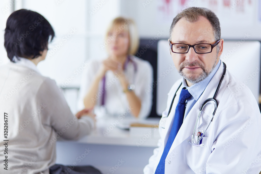 Portrait of senior doctor in office sitting at the desk Portrait of senior doctor in office sitting at the desk