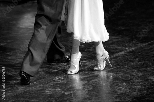 Graceful lines of legs of Argentina tango dancers in black and white