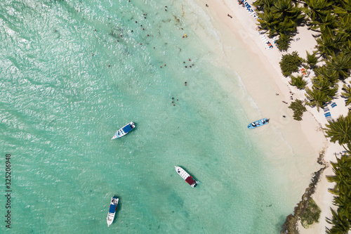 Top down drone view of boats and tourists swimming in Caribbean sea at Saona island