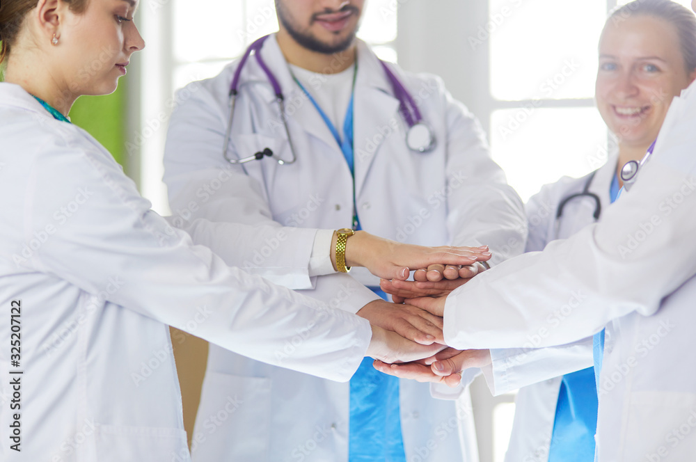 Doctors and nurses in a medical team stacking hands Doctors and nurses in a medical team stacking hands