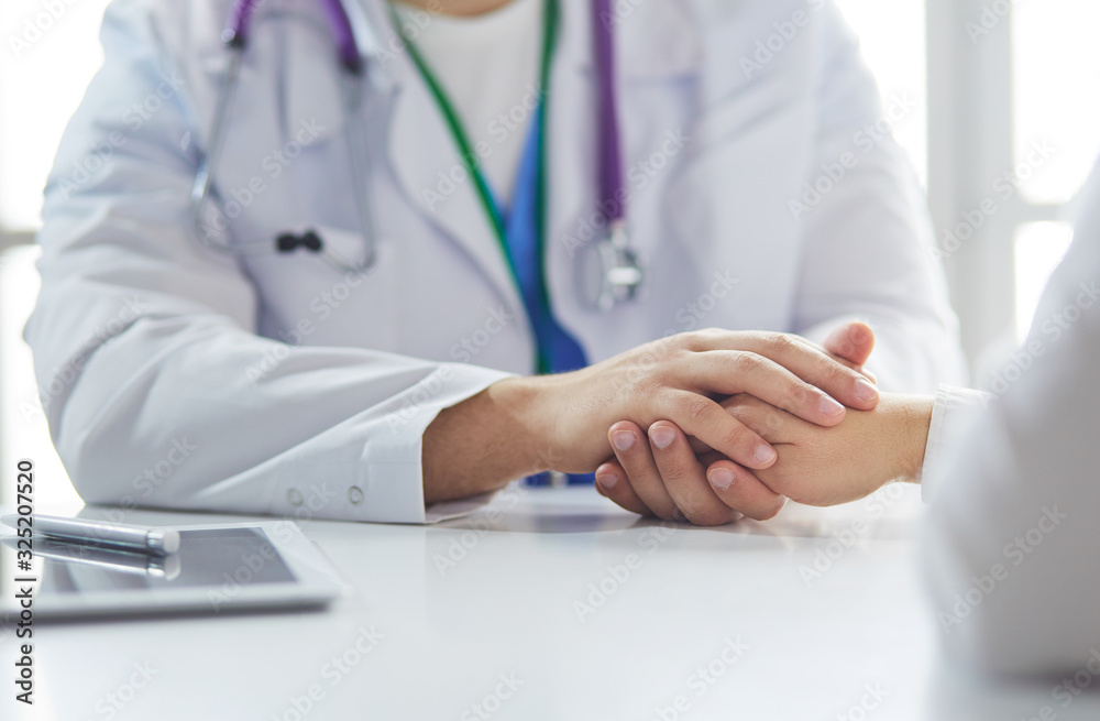 Close-up of stethoscope and paper on background of doctor and patient hands