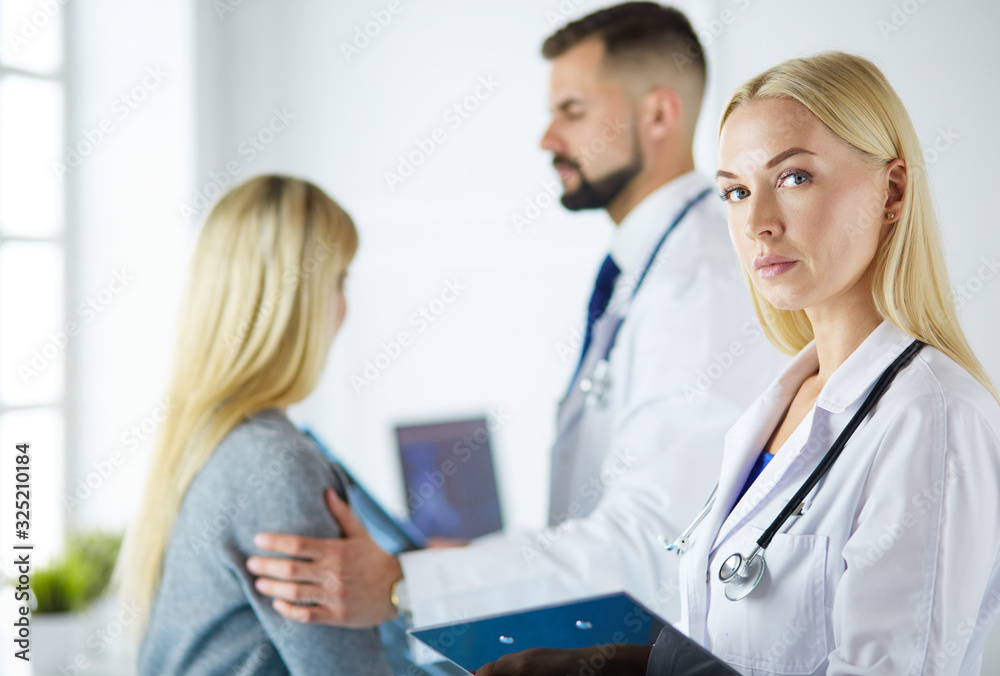 Handsome male doctor consulting a couple about infertility in his medical office Handsome male doctor consulting a couple about infertility in his medical office