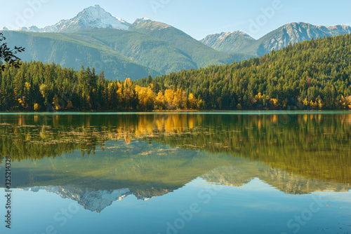 Mountains and autumn foliage reflected in Gun Lake, British Columbia, Canada
