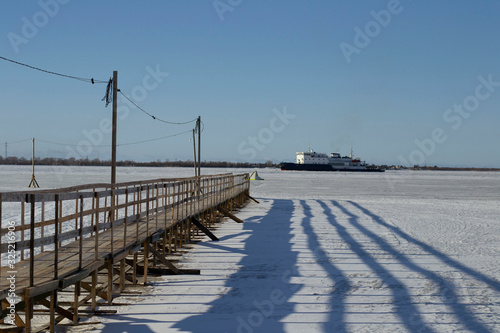 ship breaks ice on a frozen river for other ships.