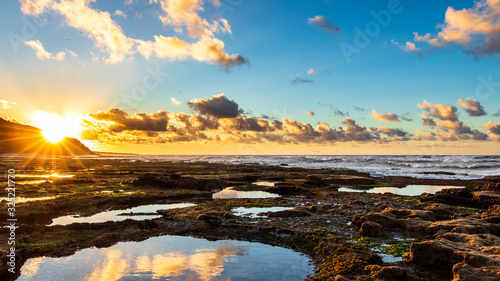Rocky coastline with small ponds at sunset time