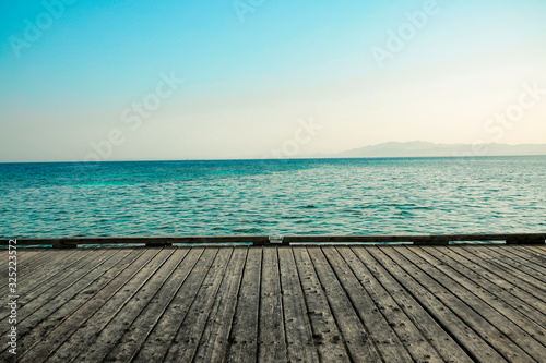 gray wooden deck of pier and blue summer sea with sky photo