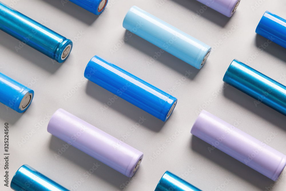 Close up of colorful used rechargeable Nickel Metal Hydride (Ni-MH) battery on grey background, flat lay. Old Nickel-Cadmium (Ni-Cd) batteries. Hazardous garbage concept Close up of colorful used rechargeable Nickel Metal Hydride (Ni-MH) battery on grey background, flat lay. Old Nickel-Cadmium (Ni-Cd) batteries. Hazardous garbage concept