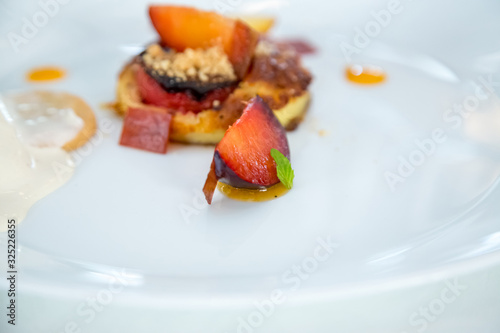 baked peach dessert with berries on a white plate