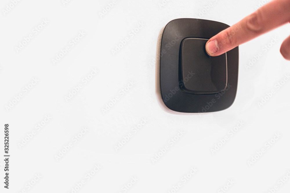 Turning off or turning light switch on wall with finger. Caucasian hand