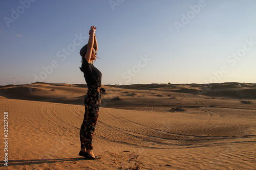 Young woman enjoying the sunset in the desert