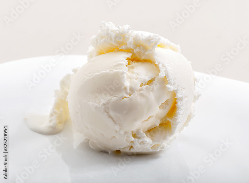 delicious ice cream scoop on white dish close-up against neutral background