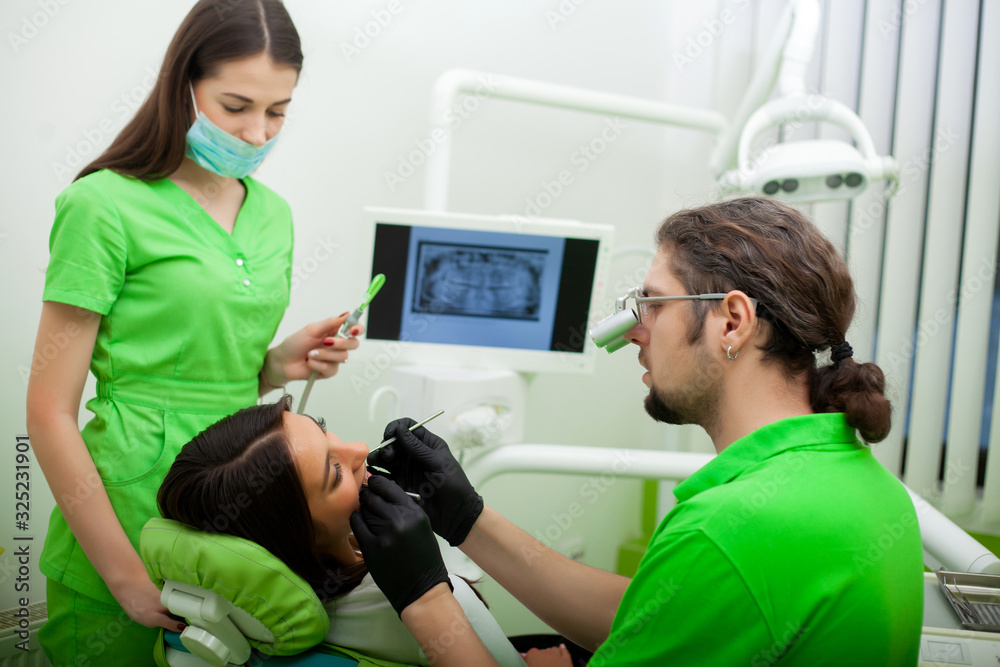 Obraz premium The dentist man are treating teeth to client in dental office