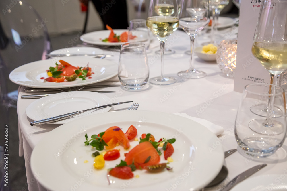 starter salad on a white plate with plated dinner