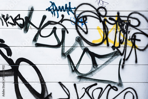 Generic black graffiti style spray painted lines on a white wall.