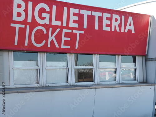 Closed ticket box office windows under big red sign photo