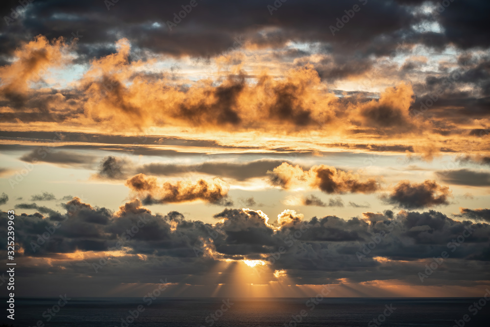 Aerial view of beautiful clouds over horizon with sun rays before sunset
