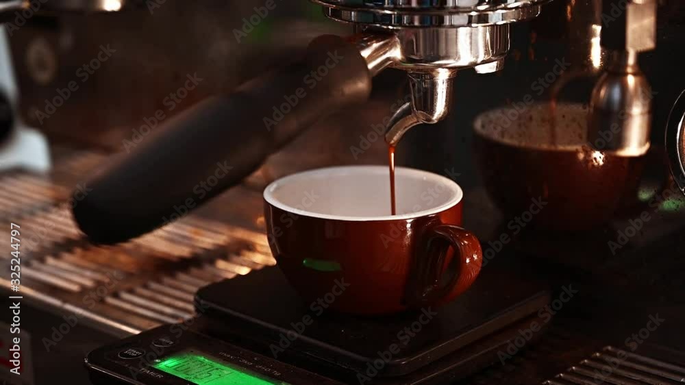 Close-up of espresso pouring from coffee machine. Professional coffee brewing. The process of how to making fresh espresso coffee.