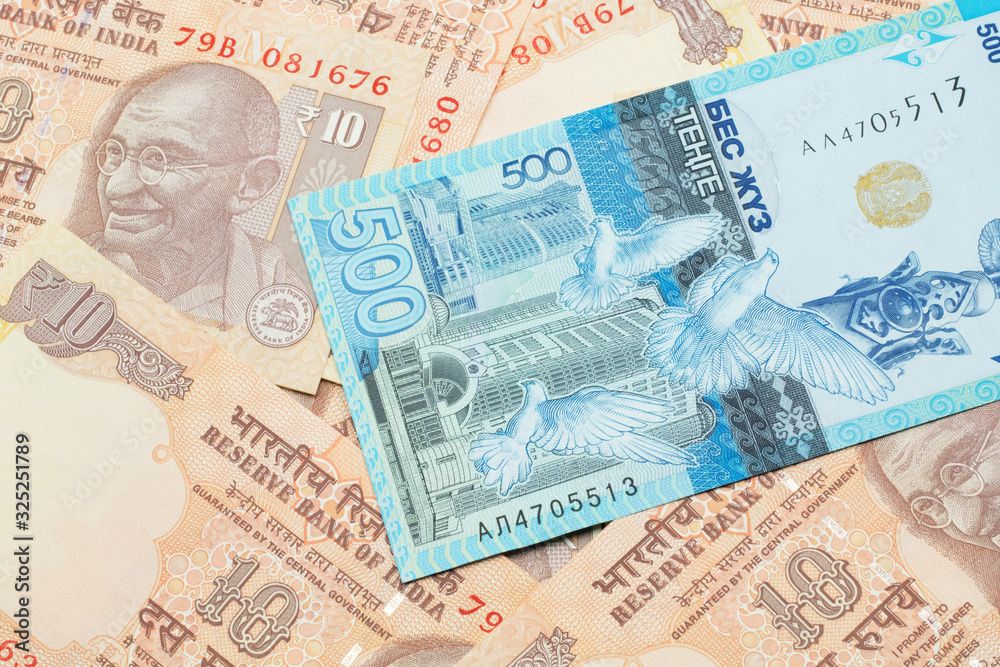 Fototapeta premium A blue five hundred tenge note from Kazakhstan with Indian ten rupee bank notes close up in macro