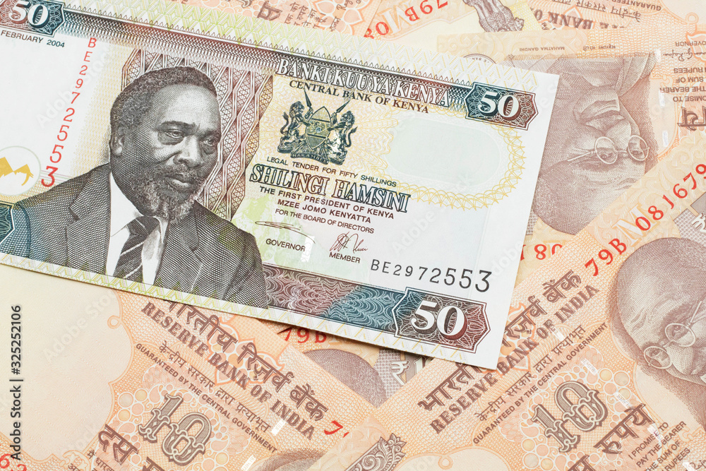 A close up image of a fifty Kenyan shilling bank note in macro with Indian ten rupee bank notes