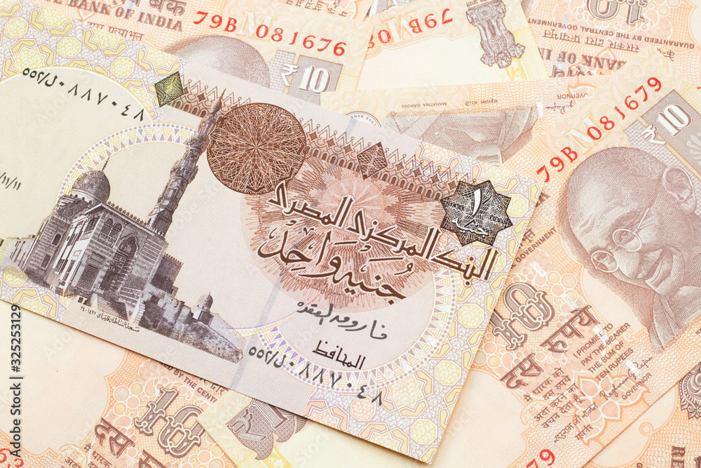 Obraz premium A close up image of an Egyptian one pound bank note with Indian ten rupee bank notes in macro