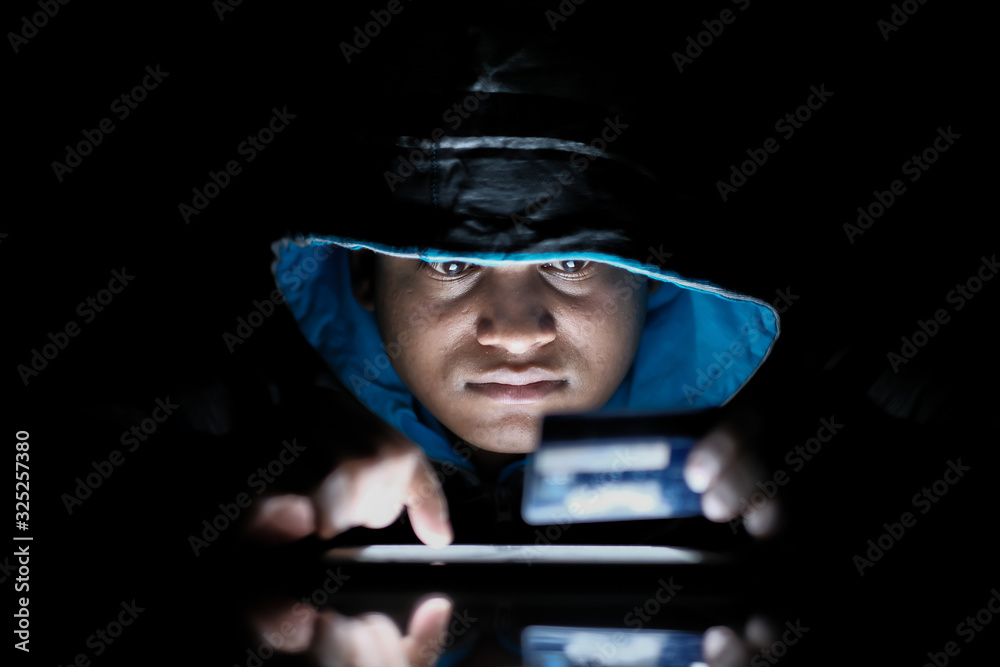 hooded hacker sealing data from laptop at night hooded hacker sealing data from laptop at night