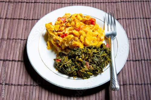 Fotografija Famous traditional Jamaican ackee & saltfish breakfast, steamed callaloo seasoned with tomatoes, thyme, onions, escallion (scallion)