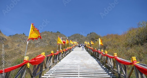 Long ladder and flags flown by the wind in Heaven Lake of Celestial Mountains and Taoist Heavenly Queen Mother temple, Xinjiang China.