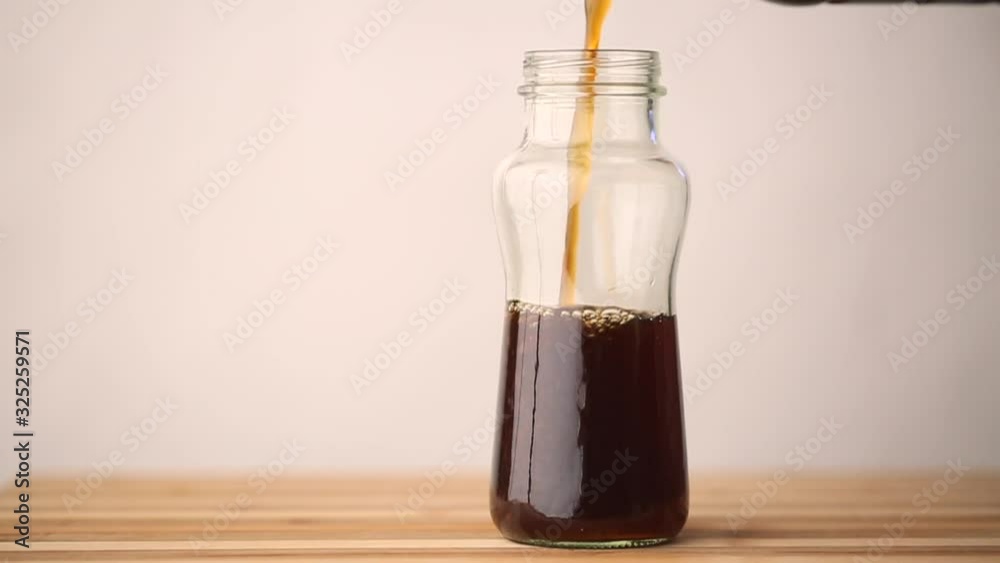 Coffee is being poured and emptied from a glass drinking container in fast motion. Coffee is being poured and emptied from a glass drinking container in fast motion.