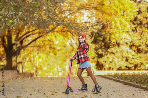 Young woman with kick scoot...