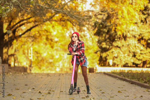 Young woman with kick scoot...