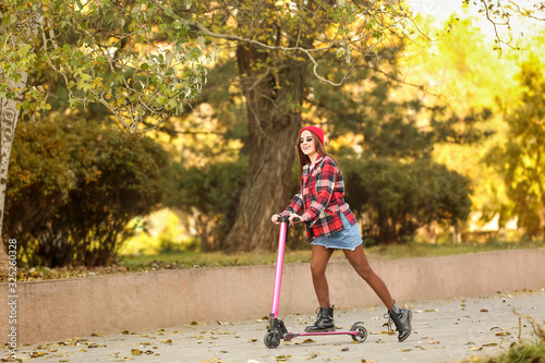 Young woman with kick scoot...