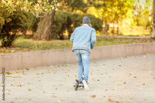 Young Person Riding Scooter...