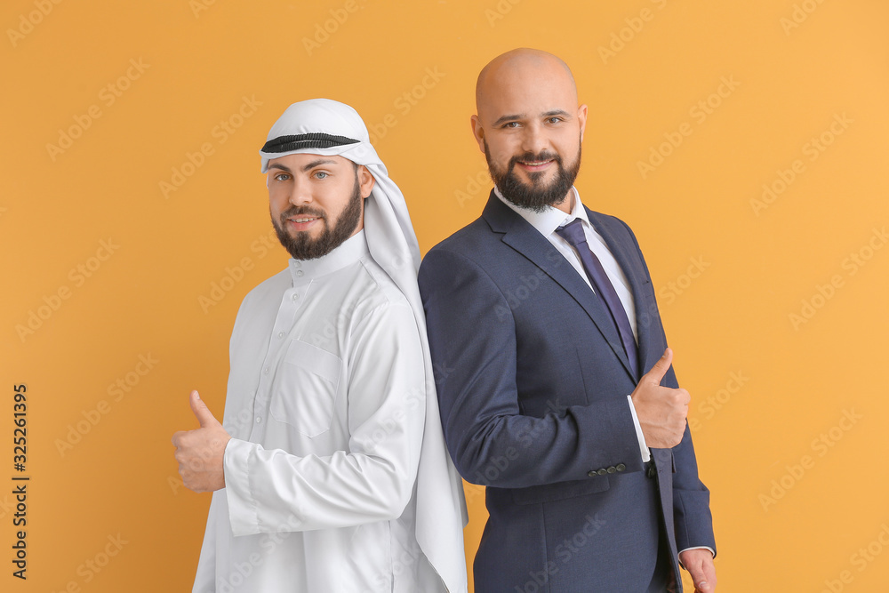 Arab man and his business partner showing thumb-up on color background Arab man and his business partner showing thumb-up on color background