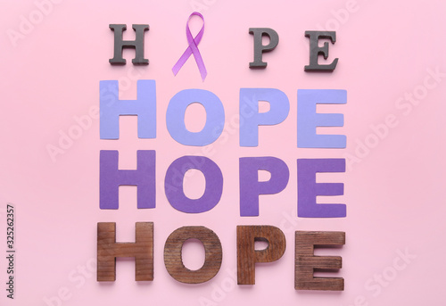 Violet ribbon and words HOPE on color background. Domestic violence concept