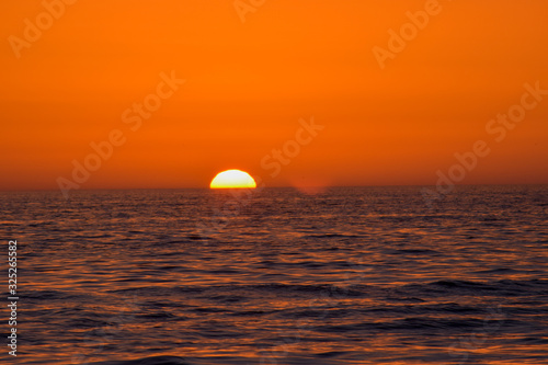 Fototapeta Naklejka Na Ścianę i Meble -  Beautiful red sunset Background in sea. A beautiful golden sunset reflecting.