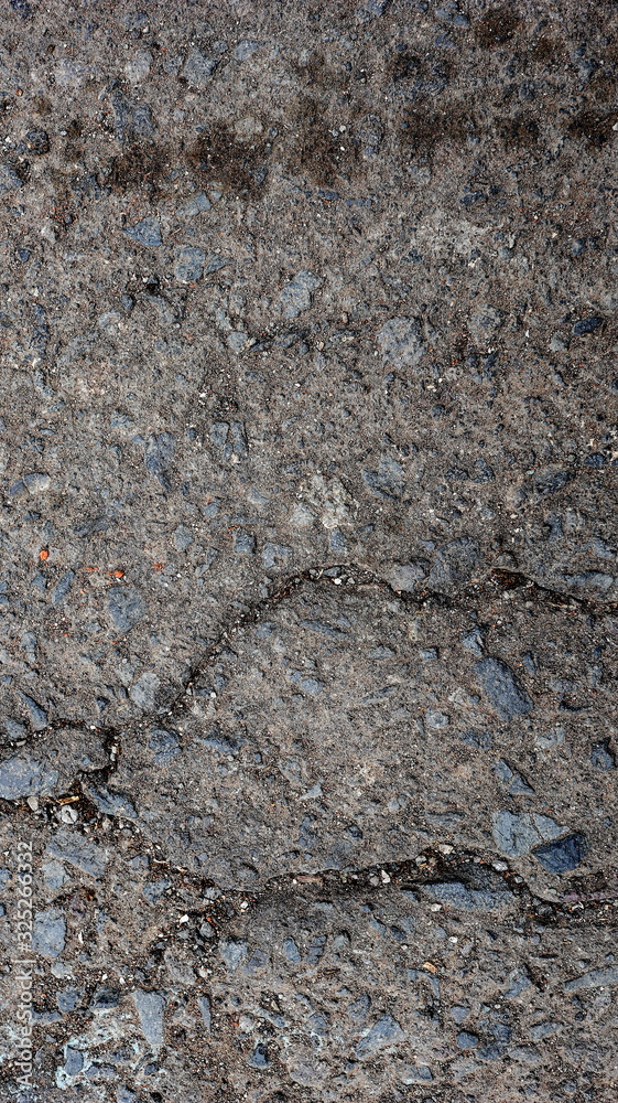 Damaged asphalt road, cracked cracks and scattered stones, with selective focus Damaged asphalt road, cracked cracks and scattered stones, with selective focus