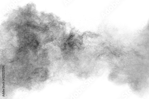 Black particles splattered on white background. Black powder dust splashing.