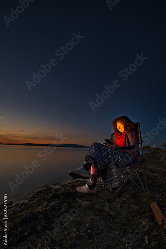 Woman in chair on the beach in the evening, Parksville, British Columbia