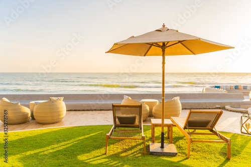 Umbrella and chair around beach sea ocean at sunset or sunrise time © siraphol