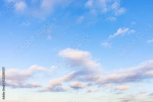 low white, gray and pink clouds in blue sky