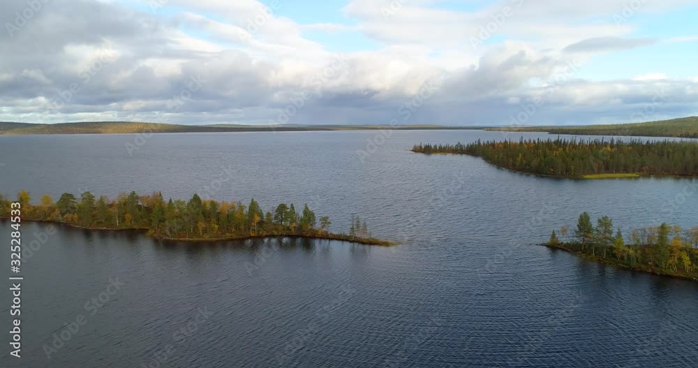 Islands on a arctic lake, Aerial, tracking, drone shot, of a isles, full of fall foliage forest, on a partly sunny, autumn day, in Pallas-Yllas national park, Lapland, Finland Islands on a arctic lake, Aerial, tracking, drone shot, of a isles, full of fall foliage forest, on a partly sunny, autumn day, in Pallas-Yllas national park, Lapland, Finland