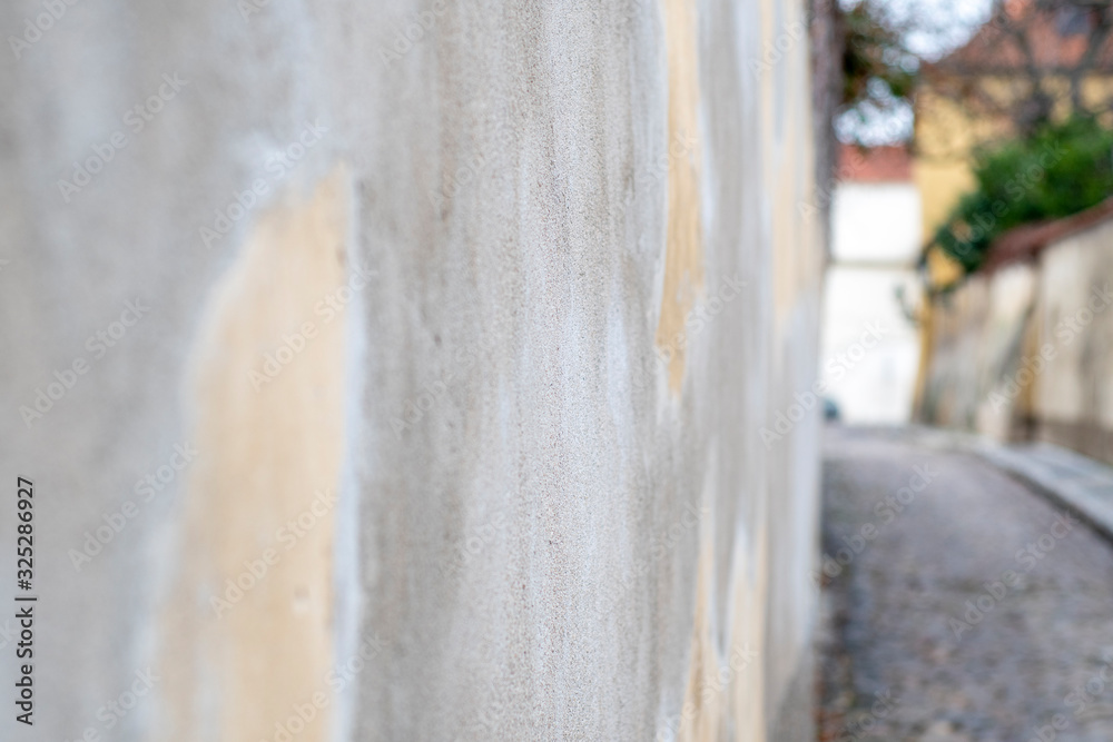 Blurred background with gray concrete wall surface and part of an old alley shot at an acute angle with low depth of field Blurred background with gray concrete wall surface and part of an old alley shot at an acute angle with low depth of field