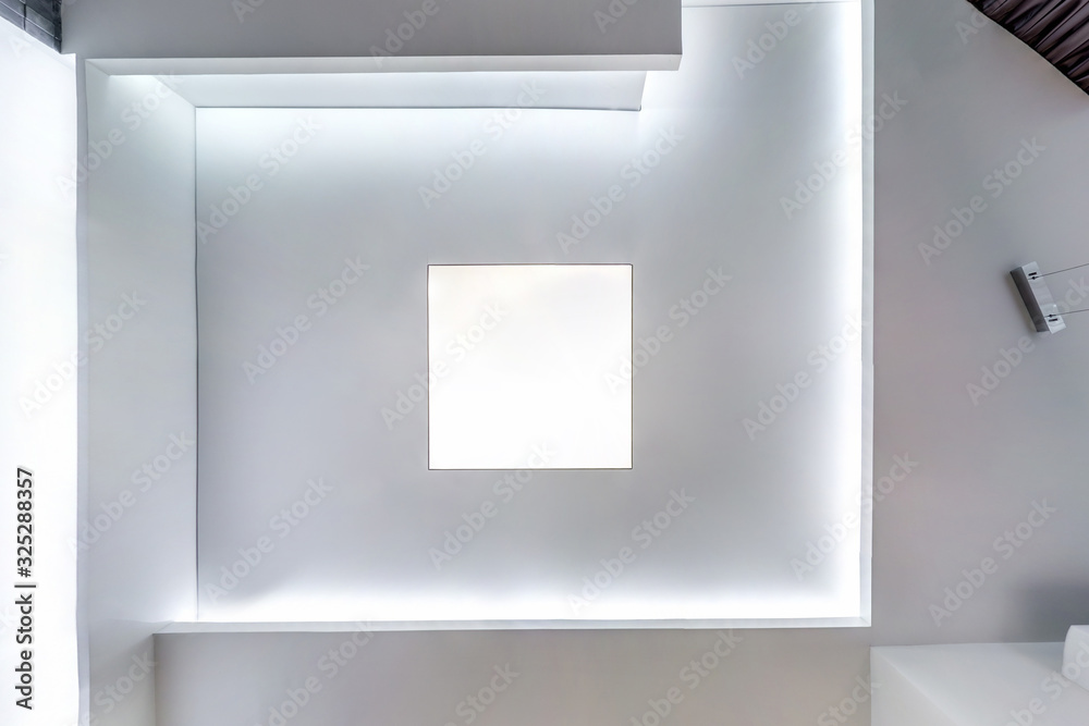 looking up on suspended ceiling with halogen spots lamps and drywall construction in empty room in apartment or house. Stretch ceiling white and complex shape. looking up on suspended ceiling with halogen spots lamps and drywall construction in empty room in apartment or house. Stretch ceiling white and complex shape.