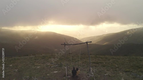 Romantic couple in Swing baloico in Lousa mountain, Portugal at sunset photo