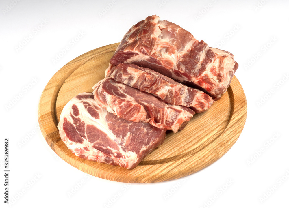 Fresh raw pork neck on wooden board isolated on white. Pork slises.