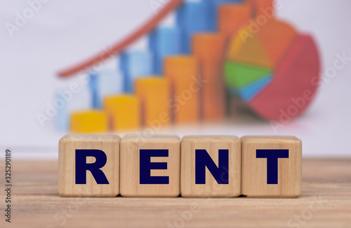 The concept of the word rent on cubes against the background of the graph