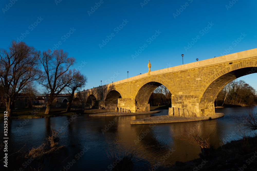 Stone bridge with in Regensburg in afternoon light on sunny day