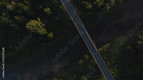 Cinematic early morning aerial flight over river Merkys valley, filled with fog and sun rays. Shot near Merkine town, not far from Druskininkai resort city. photo